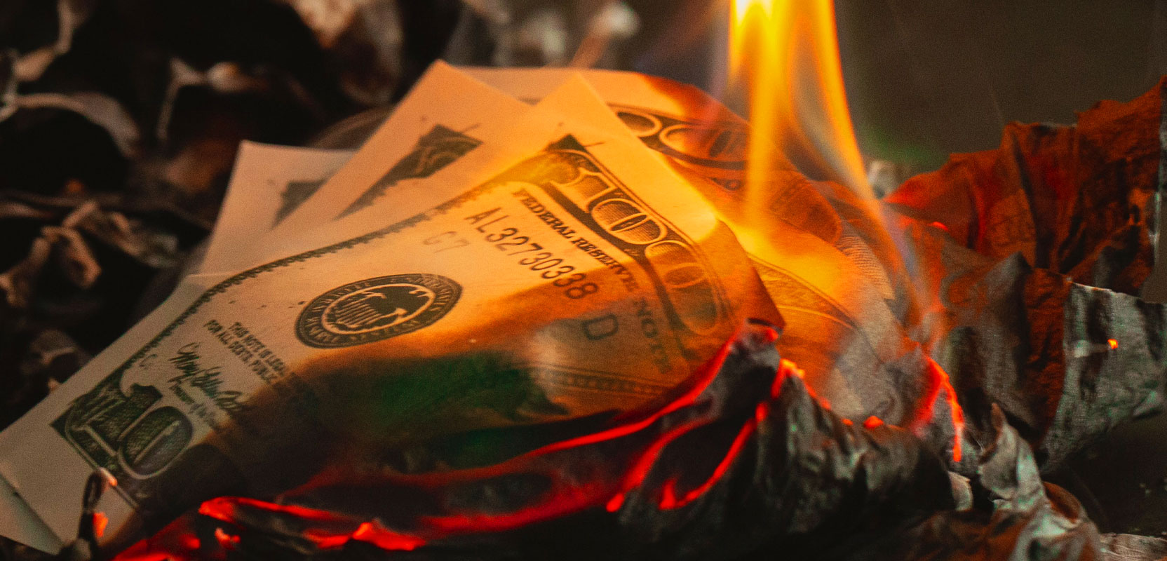 Dollar bill being set on fire by a small candle